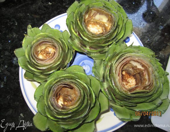 Очистить верхние два слоя листьев на цветке, все твердые листья, вытянуть ложечкой серединку (лучше одеть перчатки, так как руки могут потемнеть). Я срезаю верхушку, примерно 1/3 часть.  Положить очищенные артишоки в воду с лимоном. 
