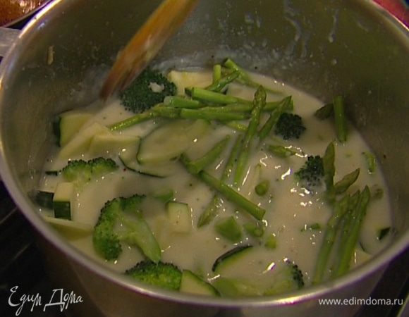 Как только суп снова закипит, всыпать зеленый горошек и варить еще минуту. Влить сливки и прогреть суп, но не кипятить. 