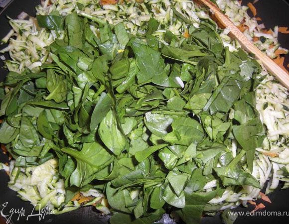 Добавить натертый на крупной терке цукини, шпинат, петрушку, соль и перец. Все размешать, продолжая жарить еще минуту.
