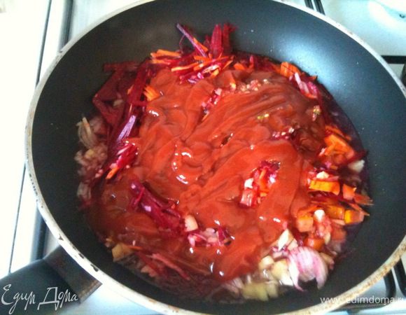 В сковороду налить немного бульона, добавить нарезанные для заправки овощи и томатный соус.