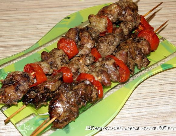 Удаляем не нужный жир и пленочки с печенки и сердечек, солим, перчим, выжимаем сок из половинки лимона, 2 ст. ложки муки, все перемешиваем. Нарезаем на кружочки помидоры. На бамбуковые шпажки нанизываем печенку и сердечки, чередуя с нарезанными помидорами. Выкладываем на противень, сбрызнутый подсолнечным маслом. Ставим в хорошо разогретую духовку на 25-35 минут. 
Приятного аппетита!