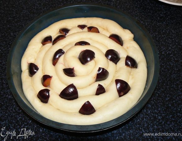 5.	Разогреваем духовку до 200 градусов. Сливы распределяем равномерно между тестом. Оставляем  пирог в теплом месте еще минут на зо.