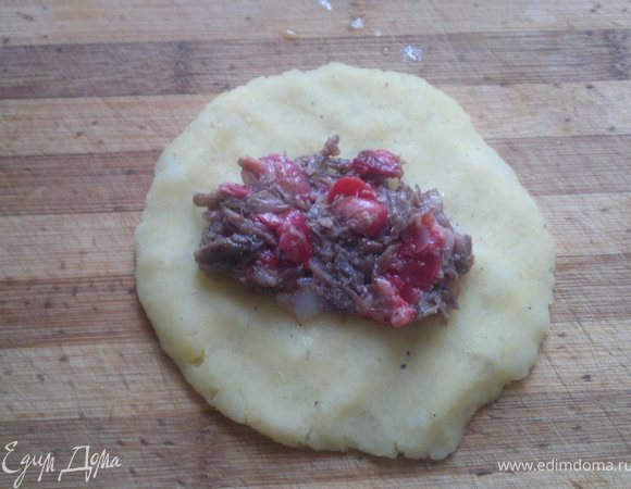 из картошки делаем кружочки,кладём на доску и прижимаем руками,кладём на неё готовую начинку(1 чайную ложку)