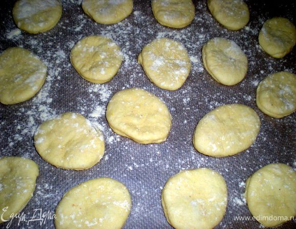 Присыпать кукурузной мукой или кунжутом.Но перед кунжутом придется смазать разболтанным яйцом,иначе кунжут ссыпется.Переложить на противень застеленный бумагой,дать немного им отдохнуть,затем выпекать при 180гр 15 минут.