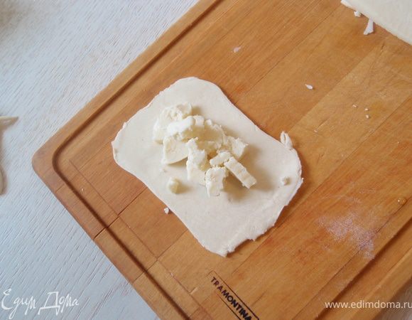 Квадратик раскатать ещё более тонко и выложить на него нарезанный сыр. Побольше, чтобы начинки было много! 