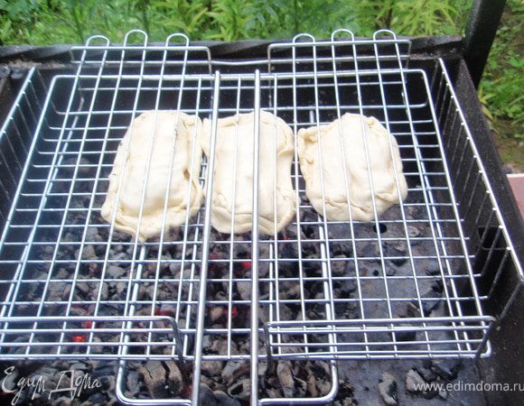 Сделать средние угли. И готовить примерно 30-40 минут постоянно переворачивая. Готовность можно определить так же как и при запекании в духовке при помощи зубочистки. А вообще и так видно, тесто сверху подрумянилось и поднялось.