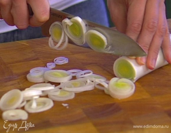 Светлую часть лука-порея нарезать тонкими кольцами. 