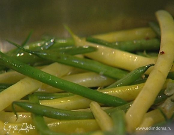 Разогреть в сковороде 2−3 ст. ложки оливкового масла, выложить в нее рубленый чеснок и фасоль, посолить, поперчить и тушить, помешивая, на медленном огне несколько минут. 