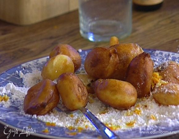 Обвалять горячие пончики в сахарной пудре с цедрой, затем полить шоколадным соусом и подавать тут же!