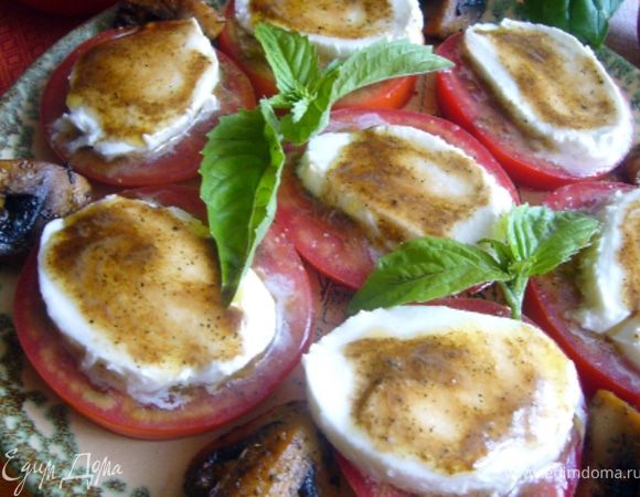 На плоской тарелке выложить помидоры, смазать заправкой, на помидоры разложить ломтики моцареллы и тоже смазать заправкой. Дать настояться 15 мин. Между помидорами выложить шампиньоны. Закуска хороша с белым вином.