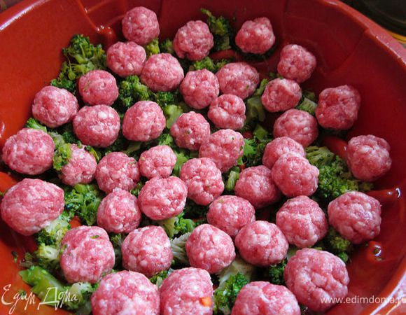 Брокколи разморозить, порезать и выложить в смазанную маслом форму. Мясной фарш посолить и скатать шарики чуть больше лесного ореха. Выложить половину на брокколи.