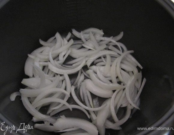 Почистить луковицу, порезать полукольцами, но не поперек, а вдоль луковицы (так сок не вытекает, а соответственно и витамины остаются). В кастрюлю мультиварки (или просто казанок) добавить масло, включить режим запекания (или поставить на средний огонь), добавить масло, выложить лук.