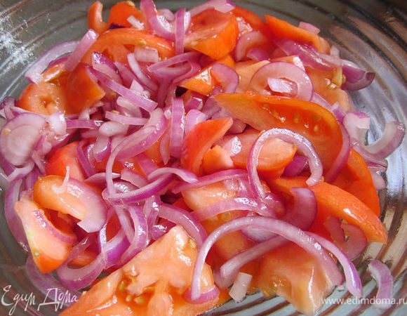 Красный салатный лук нарезать полукольцами, выложить в салатник, посолить и помять руками. Крупно нарезать помидор, выложить к луку, сбрызнуть оливковым маслом и перемешать.
