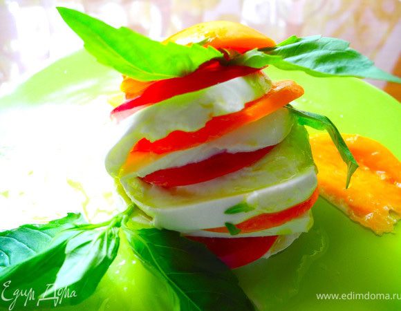 Моцареллу и помидоры порезать тонкими ломтиками. Уложить их друг на друга. Добавить базилик. Полить оливковым маслом обязательно хорошим, первого отжима, нерафинированным. Посыпать обжаренными кедровыми орешками.