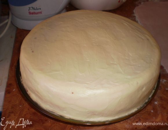 Взбить сливочное масло со згущенкой. Этим кремом обмазать торт сверху и сбоку. Тщательно разровнять.