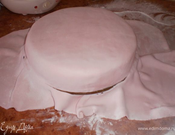 Покрыть торт мастикой, хорошо разровнять.