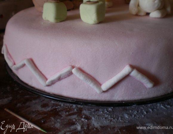 Обрезки из конфеток прикрепить на торт при помощи воды.