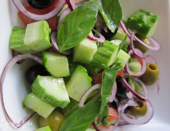 Томат и огурец порезать, лук нашинковать тонкими колечками, базилик разобрать на листочки. Добавить маслины и оливки. Все перемешать. 