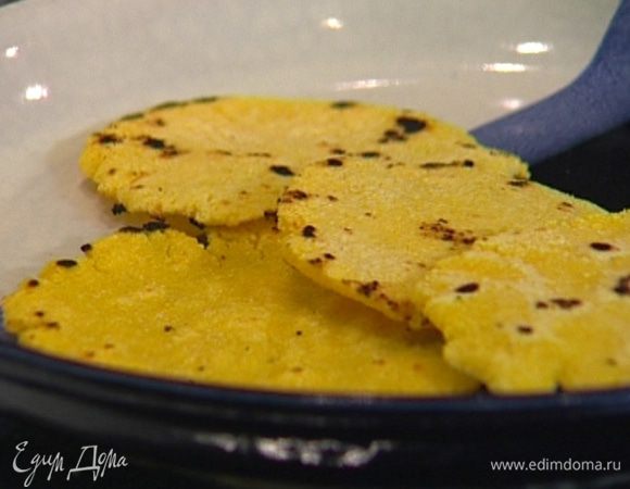 Приготовить тесто, смешав кукурузную муку и 175 мл теплой воды. Разделить тесто примерно на 10–12 частей, сделать из них тонкие небольшие лепешки и жарить на сухой разогретой сковороде по 2–3 минуты с каждой стороны.