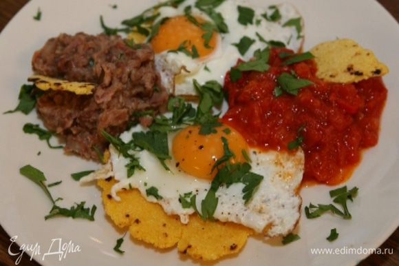 Яйца пожарить, выложить по одному на каждую лепешку и подавать с томатным соусом и фасолью, присыпав петрушкой.