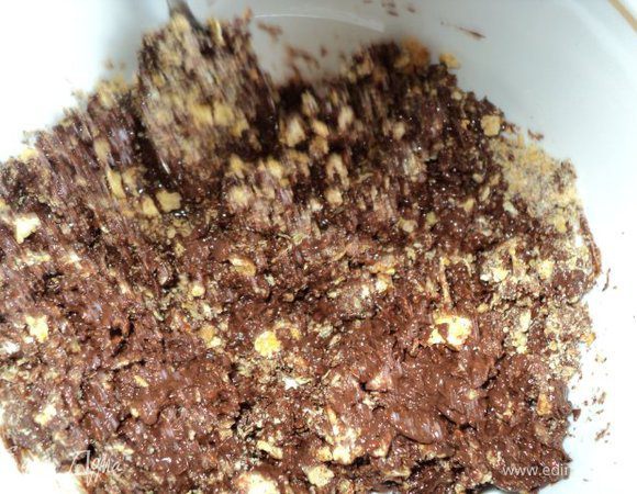 Шоколад поломать на кусочки, положить в керамическую или стеклянную миску, растопить в микроволновке ( при максимальной мощности 1мин 20сек) или на водяной бане.
К растопленному шоколаду добавить измельченные кукурузные хлопья, молотый миндаль, перемешать.
