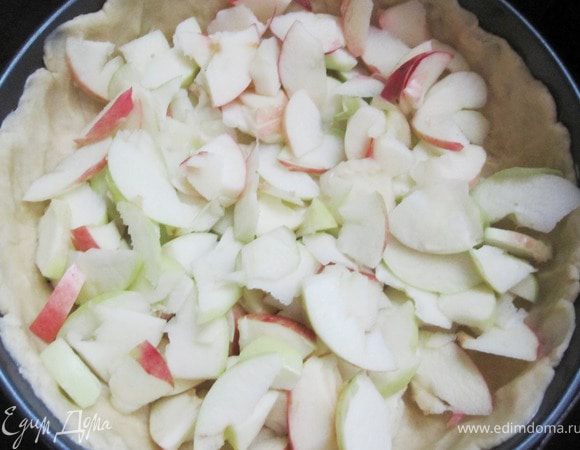 Яблоки вымыть, почистить, вырезать сердцевину, нарезать тонкими ломтиками и распределить по форме.