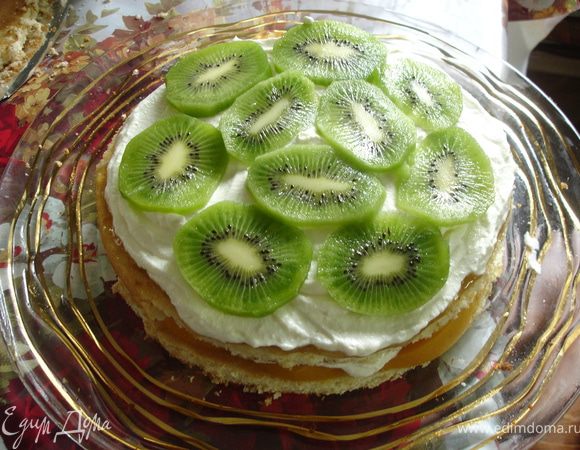 Творожный крем. 500 г творога протереть через сито. Отдельно взбить 200 мл сливок со 100 г сахарной пудры до загустения. Постепенно добавить 150 г сыра Альметте, творог, ванилин, сахарную пудру по вкусу. Тщательно перемешать миксером на небольших оборотах. Крем должен быть густой. Полученный крем выложить на персики. Далее уложить следующий корж, пропитать, намазать персиковым джемом, уложить слой крема, затем киви, нарезанных кружочками. Сверху уложить третий корж.