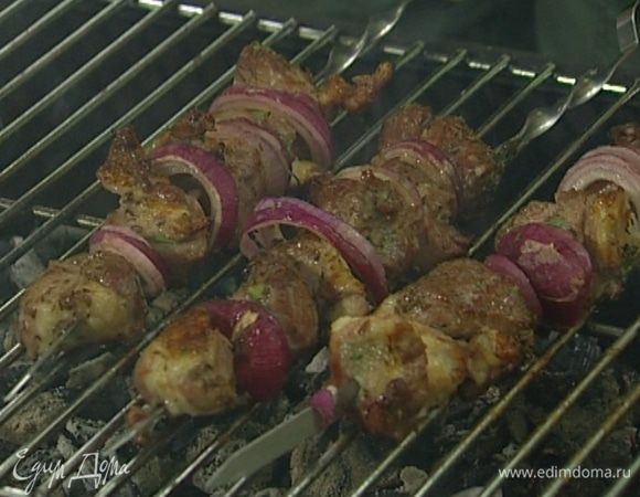 Куски баранины и кольца лука нанизать на шампуры и пожарить на гриле, время от времени поливая маринадом. Готовый шашлык посолить.