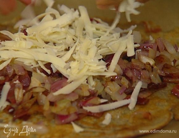 Разложить блины на противне, выстеленном бумагой для выпечки, сверху выложить поджаренный бекон и лук, присыпать все натертым сыром и отправить в разогретую духовку на несколько минут. 