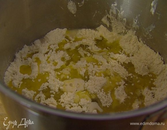 Влить в закваску вино, оливковое масло, еще 90 мл теплой воды и вымешать тесто ложкой.