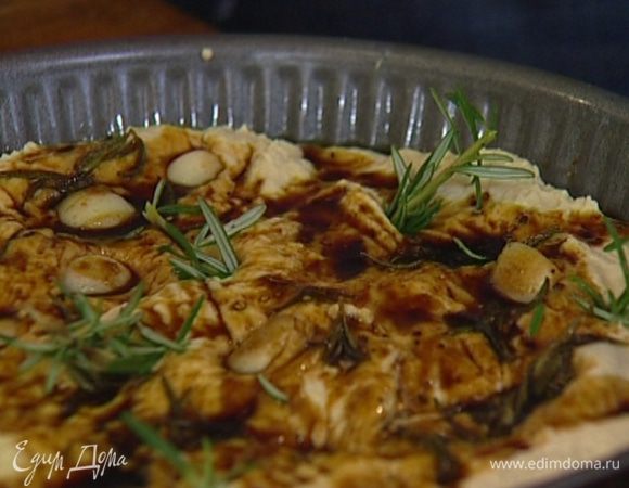 Смазать форму для выпечки оливковым маслом, выложить тесто, полить чесночным соусом, а сам чеснок воткнуть поглубже в тесто. Разломить веточку розмарина на маленькие кусочки и воткнуть в тесто.