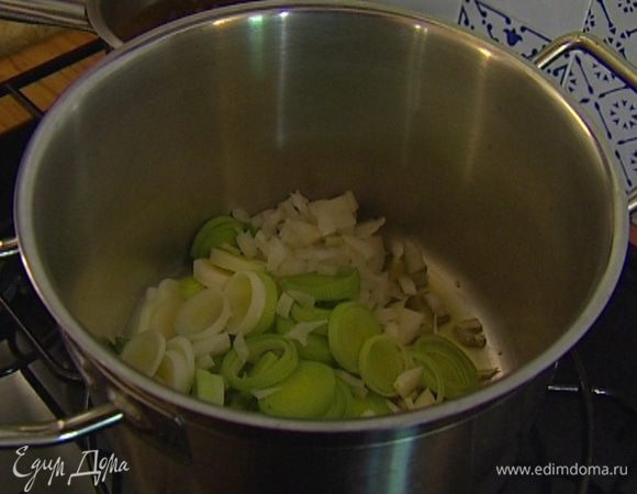 Разогреть в тяжелой кастрюле оливковое и сливочное масло, добавить лук-порей и половину нарезанного репчатого лука и томить все на среднем огне до мягкости.
