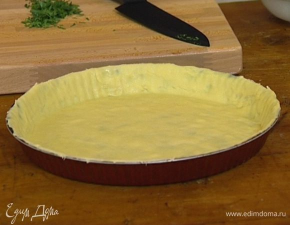 Охлажденное тесто раскатать, выложить в смазанную сливочным маслом форму для запекания, проткнуть вилкой в нескольких местах и застелить бумагой для выпечки. 