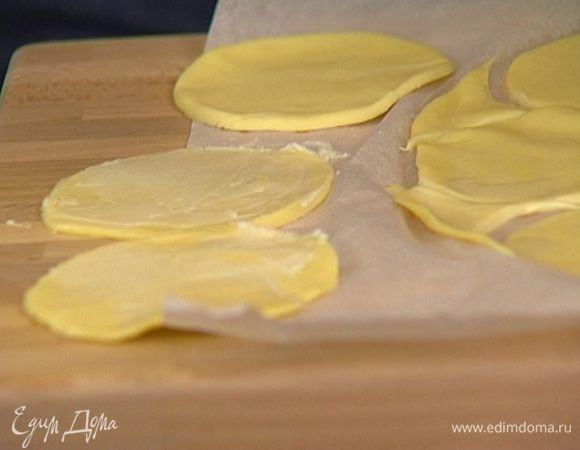 Тесто раскатать, вырезать из него небольшие кружки диаметром 8–10 см и смазать их предварительно размягченным сливочным маслом. 