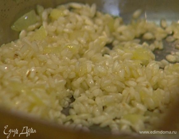 Всыпать рис и, помешивая, дать ему пропитаться ароматами масла, лука и чеснока. 