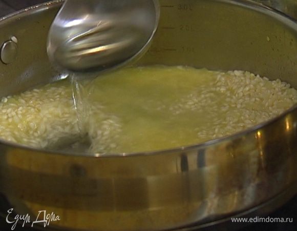 Не переставая мешать, постепенно, половник за половником, добавлять подогретый бульон (следить, чтобы рис не плавал в жидкости, а впитывал ее). Готовить ризотто 15–18 минут.