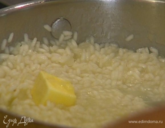 Вмешать в ризотто 20 г сливочного масла, слегка посолить, всыпать натертый пармезан (немного сыра оставить). 