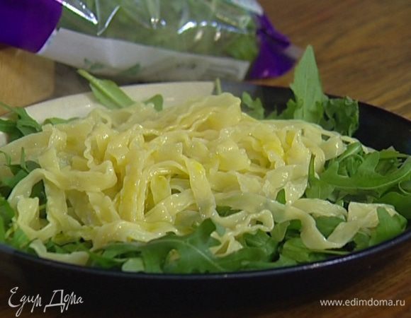 Разложить на тарелке руколу, выложить сверху макароны, сбрызнуть оливковым маслом.