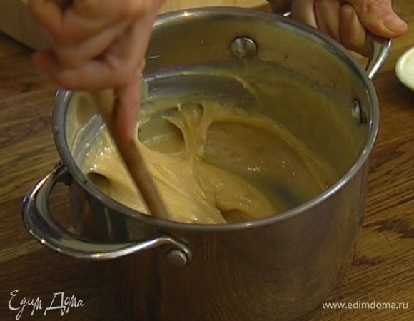 Сгущенку выложить в небольшую кастрюлю, добавить оставшееся сливочное масло и, помешивая, варить на медленном огне, пока сгущенка не загустеет и не приобретет светло-карамельный оттенок.