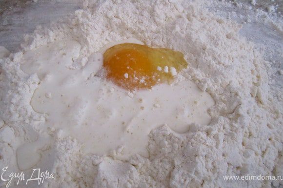 В муку сделать углубление, вбить яйцо, добавить щепотку соли, понемногу влить сметану с водой. Замесить тесто.