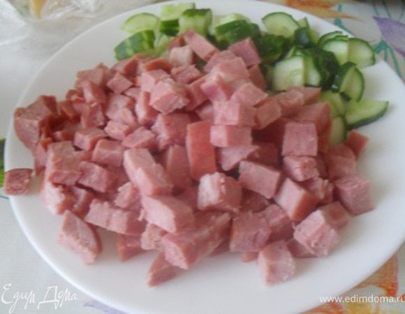 Тем временем порезать кубиком ветчину и огурец, смешать.