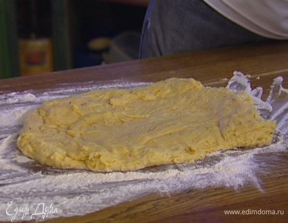 Присыпать рабочую поверхность мукой, выложить тесто, слегка распластав его. 