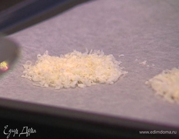 Выстелить противень бумагой для выпечки, выложить на нее оставшийся натертый пармезан в форме небольших лепешек и отправить в разогретую духовку на 5−7 минут.