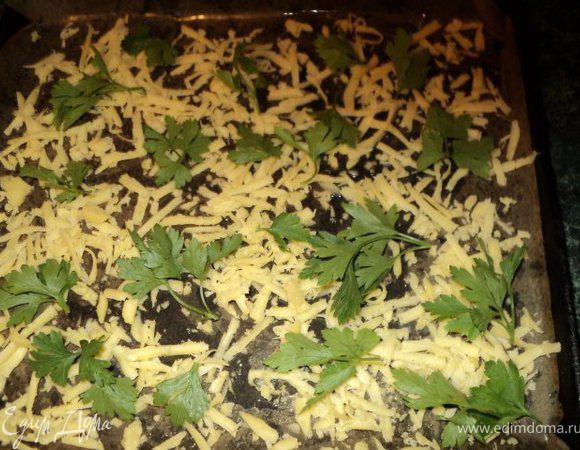 Противень застелить бумагой для выпечки, смазать маслом, посыпать равномерно натертым сыром, сверху разложить веточки петрушки.
