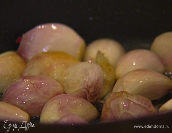 Отправить лук-шалот и зубчики чеснока в сковороду, где готовился кролик, и обжарить до карамельного цвета.