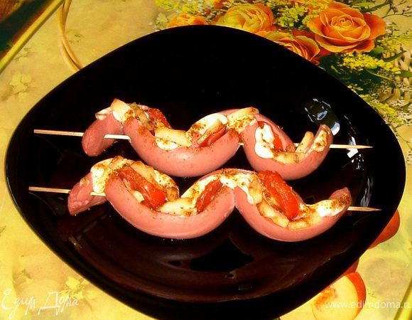 Поставить в разогретую до 200 градусов духовку. Запекать 15 минут до лёгкого поджаривания сосисок.