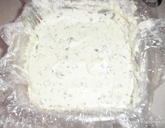 Добавить желатин, еще раз хорошо взбить. Форму застелить изнутри пищевой пленкой, вылить творог сверху(форма в идеале должна быть продолговатой прямоугольной, у меня такой не оказалось, делала в квадратном контейнере).Разровнять и поставить на застывание в холодильник на 2 часа.
