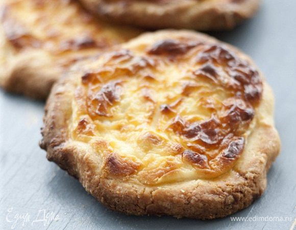 Отделить желток от белка. Желток слегка взбить вилкой, добавив 1 ст. ложку холодной воды, и смазать ватрушки. Выпекать в разогретой духовке 20−25 минут до золотистого цвета.