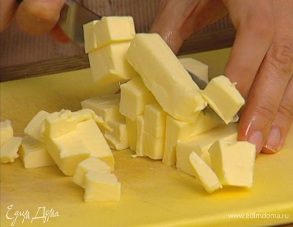 Предварительно охлажденное сливочное масло порезать маленькими кусочками.