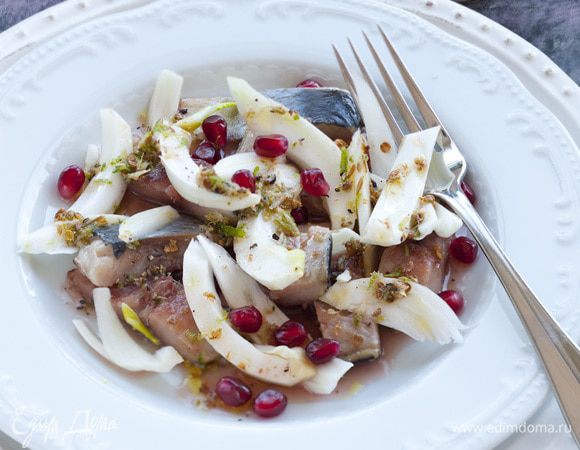 Выложить на тарелку слой селедки, затем слой фенхеля, полить все заправкой, украсить зернами граната.